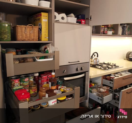 ארונות מטבח מאורגנים עם מוצרי מזון וכלים